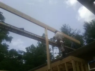 Carpenter setting a ridge beam over a new addition frame — Ice Dam Removal by Roofing Brothers in Pryor