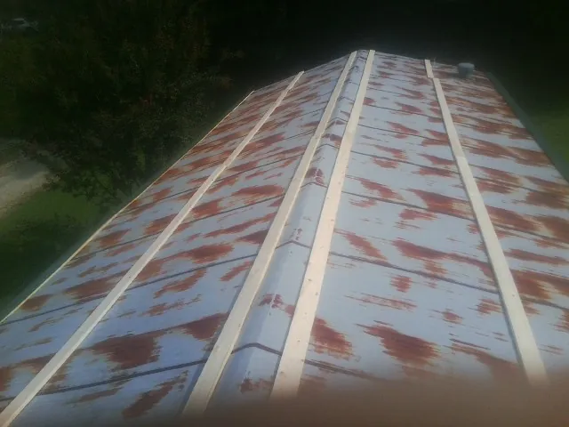 Rusted metal roof panels with new wood purlins before replacement — Storm Damage Roof Repair in Pryor by Roofing Brothers