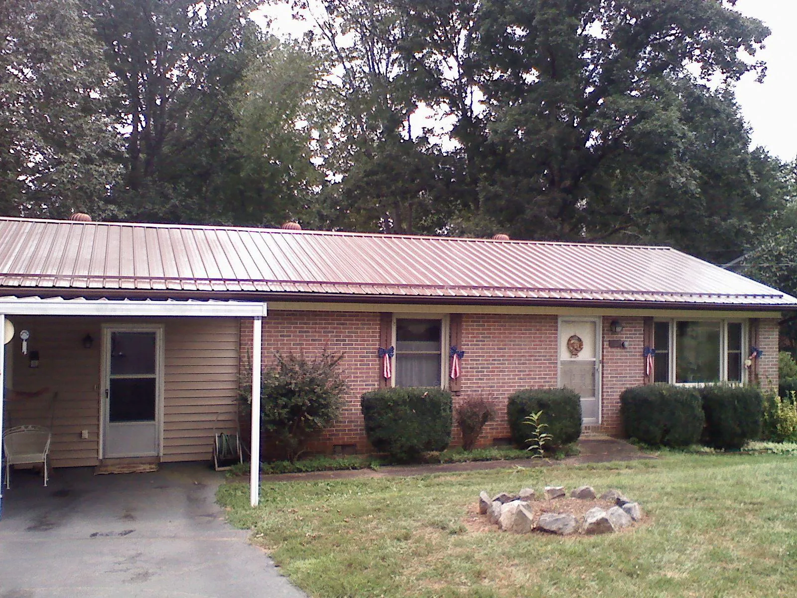 Bronze metal roof and carport on a brick ranch home — Roof Repair work by our crew in Pryor