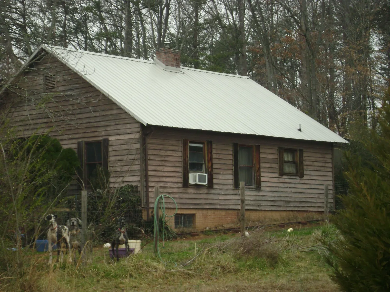 White metal roof on an old wood sided farmhouse, from a Asphalt Shingle Roof Repair job in Pryor